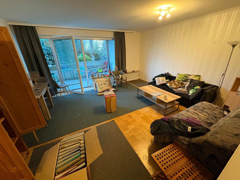 Wohnzimmer mit Sofa und Teppichen vor der Haushaltsauflösung